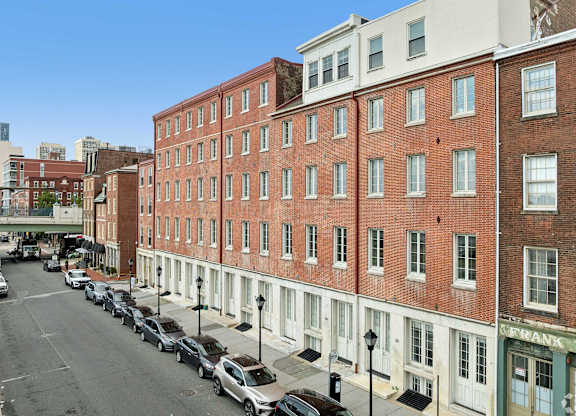 A street view of a city with a red brick building on the right.