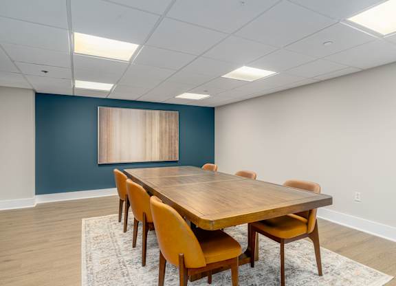 A conference room with a long table and chairs.