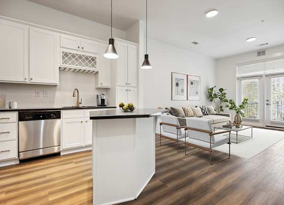 A modern kitchen with white cabinets and a wooden island.