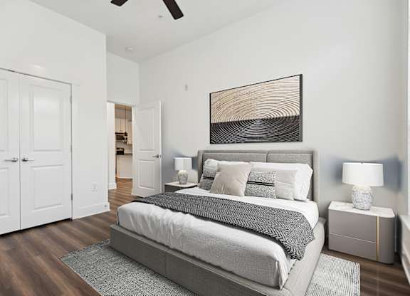 A bedroom with a large bed and a ceiling fan.