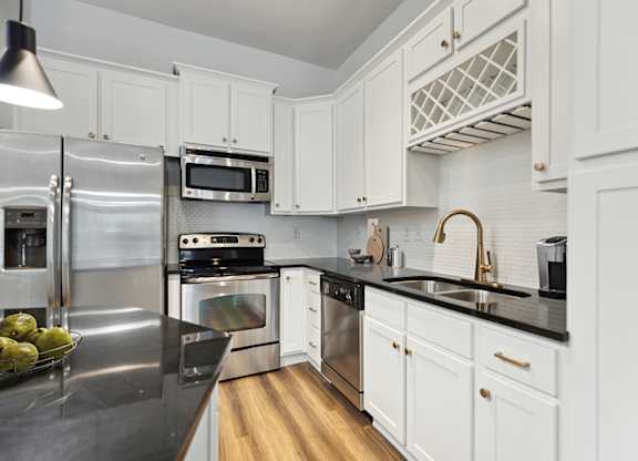 A modern kitchen with white cabinets and stainless steel appliances.