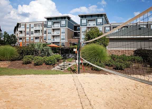 A volleyball net is set up on a sandy court.