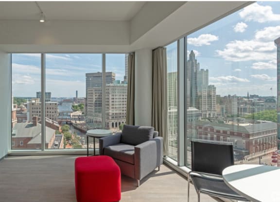 a living room with a view of the city and a table and chairs