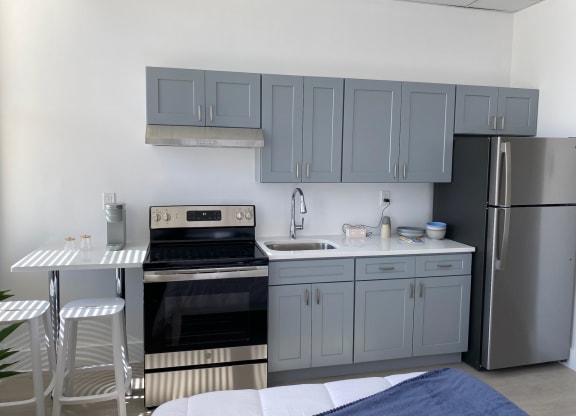 a kitchen with blue cabinets and stainless steel appliances and a table and chairs
