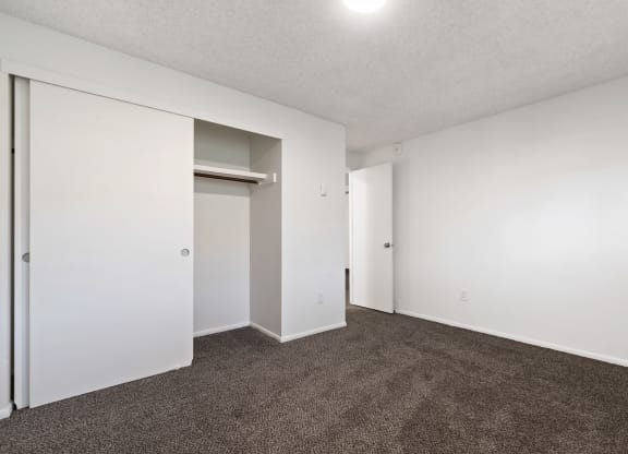 an empty living room with carpet and white walls