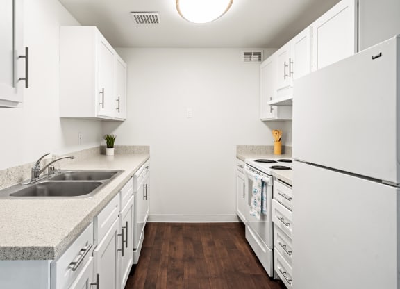 Bright white kitchen with dark faux wood flooring, new cabinets and countertops.at North Pointe, Post Falls, ID