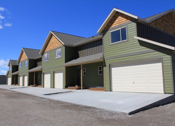 a row of green houses with white garage doorsat Copper Pines, Bozeman, 59718