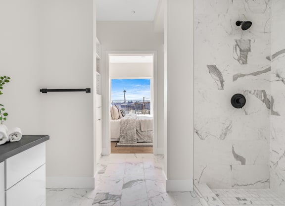 a bathroom with a view of a bed and a door to a bedroom  at Oslo, Seattle, WA