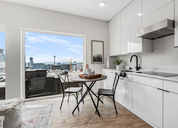 an open kitchen with a table and chairs and a window overlooking the city  at Oslo, Seattle, WA