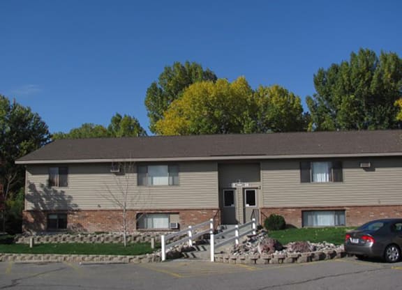 a tan house with a car parked in front of it at Rock Creek, Billings