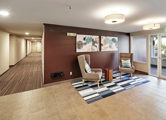 a lobby with two chairs and a rug at Townside Flats, Redmond, 98052