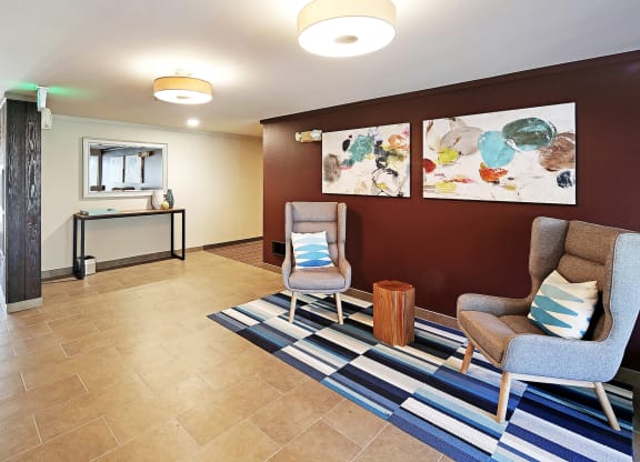 a lobby with two chairs and a rug and a table  at Townside Flats, Washington, 98052