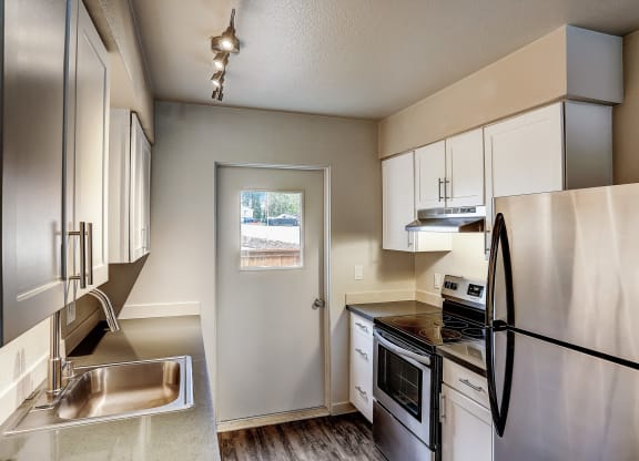 a kitchen with stainless steel appliances and white cabinets at Woodcreek, Poulsbo, WA