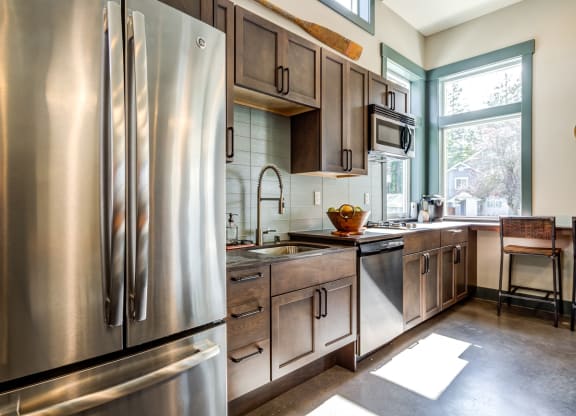 a kitchen with stainless steel appliances and wooden cabinets at Woodcreek, Poulsbo, WA 98370