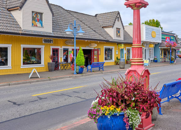a large clock on the side of a street with a vase of flowers at Woodcreek, Washington, 98370
