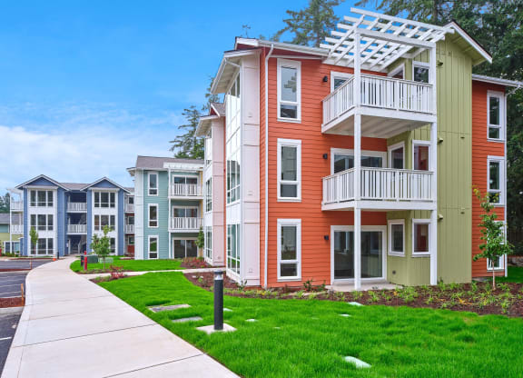 an apartment building with a sidewalk in front of it at Woodcreek, Poulsbo