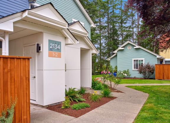 a white and blue house with a sidewalk in front of it at Woodcreek, Poulsbo Washington