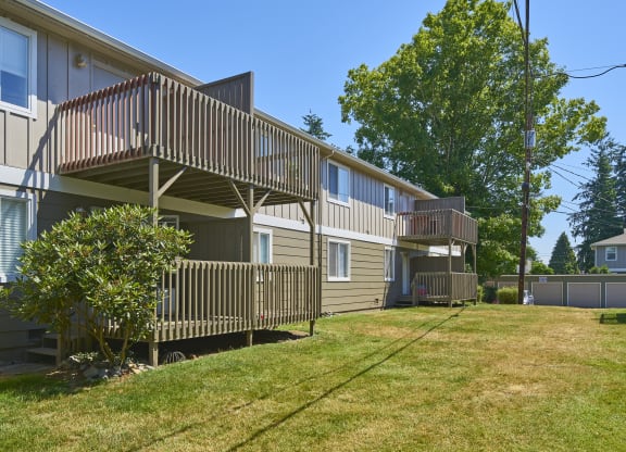 the back of two houses with balconies and a grass yard  at Woodhaven, Washington, 98203