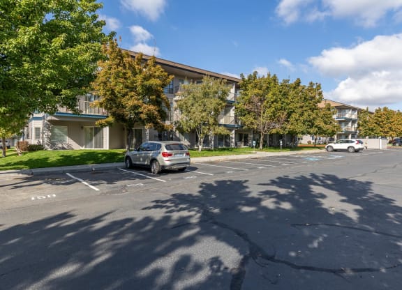 a parking lot with a car parked in front of an apartment building  at Shoreline Village, Richland, 99352
