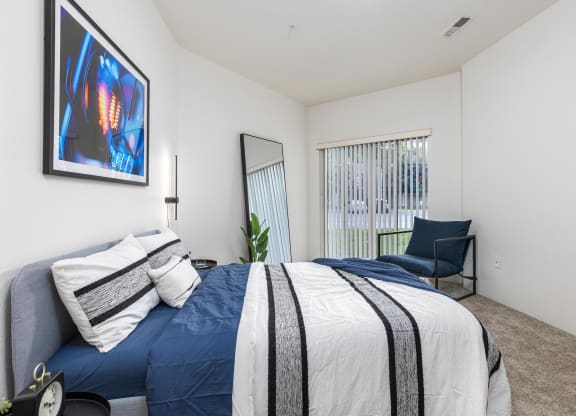 a bedroom with a blue and white bed and a chair  at Shoreline Village, Richland