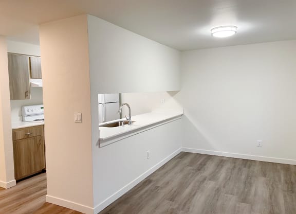 Dining area with wood-style flooring to the right, and the kitchen with a pass through window to the left.at The Trail, Washington