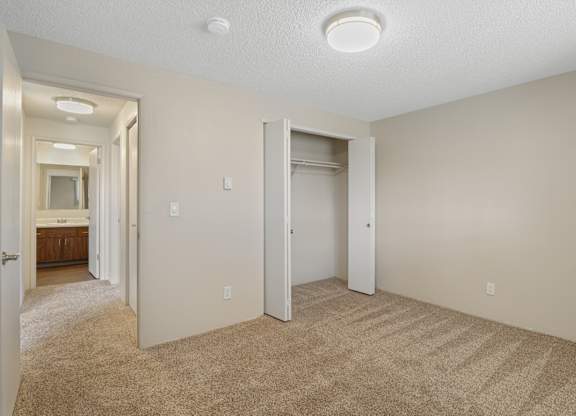 A bedroom with a carpeted floor and a ceiling light.
