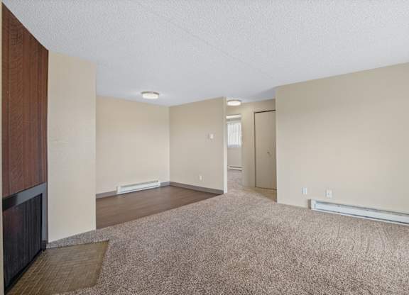 A room with a carpeted floor and a door.