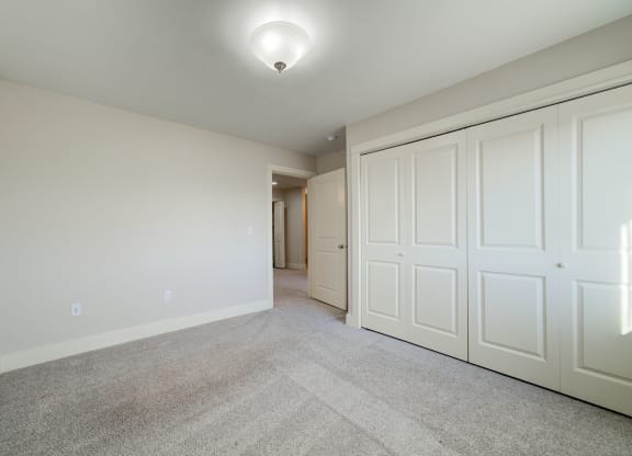 a bedroom with two closets and a carpeted floor at Copper Pines, Bozeman, MT