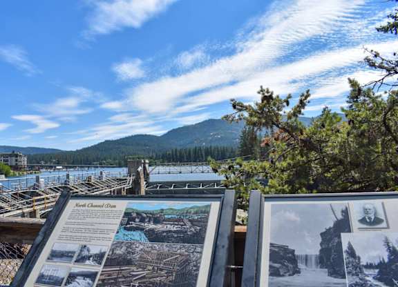 A sign with a picture of a man and a woman is in front of a body of water.