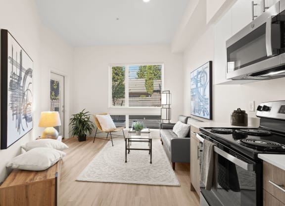 a living room with a kitchen and a large window at The Duo, University Place Washington