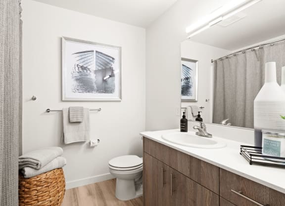 a bathroom with a sink and a toilet and a mirror at The Duo, University Place Washington