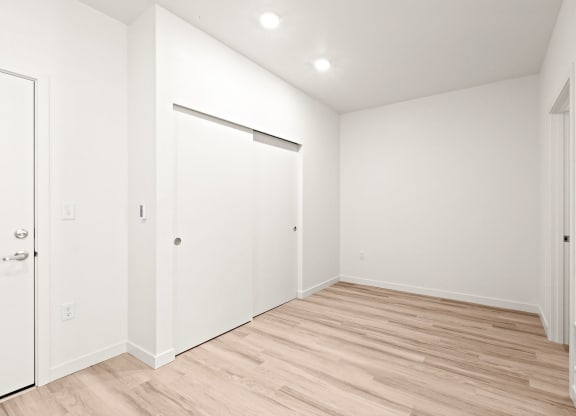 a living room with white walls and a wood floor at The Duo, University Place