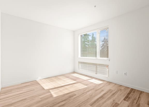 a living room with a large window and wooden floors at The Duo, University Place, WA