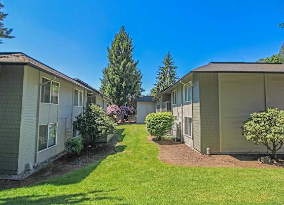 A sunny day at a residential complex with well-maintained lawns and trees.