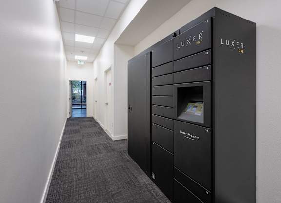 A hallway with a row of black lockers on the right side.