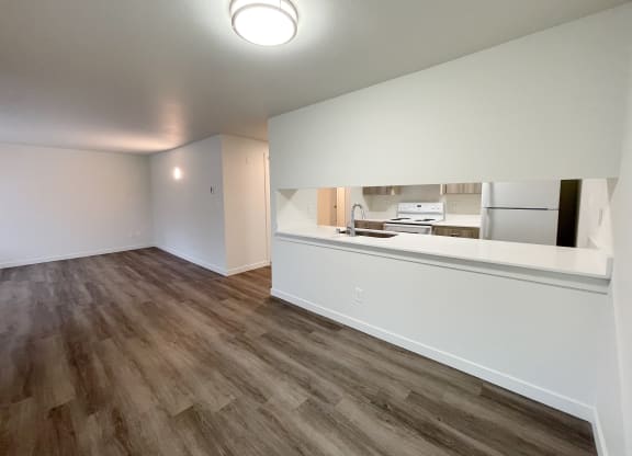Open living room and dining area looks into the kitchen with white countertops.at The Trail, Washington, 98290