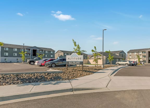 Exterior view of community buildings and parking lot. Bright blue sky and well-maintained landscaping. at Altitude, East Wenatchee