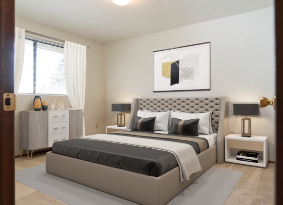 Large bedroom with natural light from window staged with bed, side tables, and wall art. at Hawks Prairie, Olympia