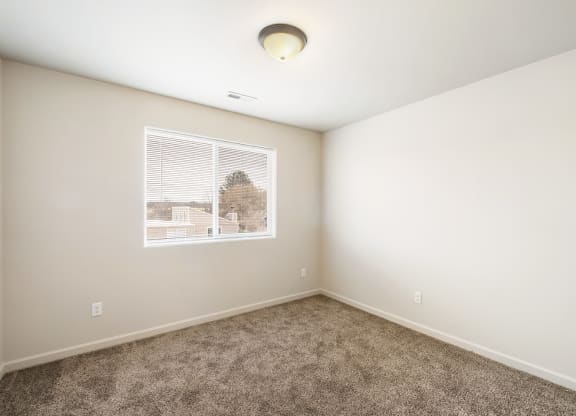 a bedroom with white walls, carpet, a large window and overhead lighting. at Pine Tree Park, Washington, 99337