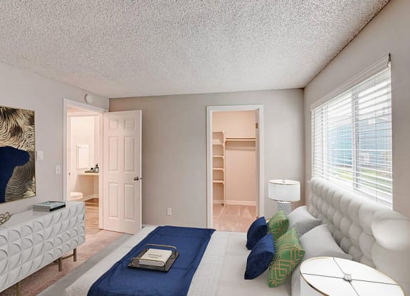 A bedroom with a spacious closet on the back wall and an oversized window above the queen-size bed. at Pointe East, Fife, WA, 98424