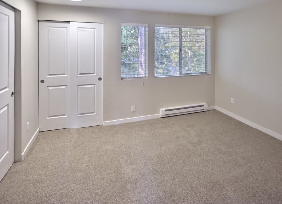 an empty room with carpet and a white door and window