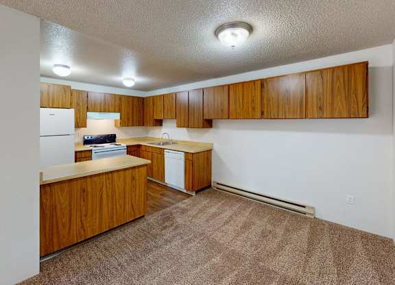 Spacious kitchen area at Heritage Grove Apartments Renton WA featuring timber-style cabinets, ample counter space, and overhead lighting.