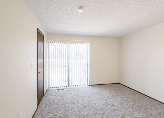 an empty living room with a sliding glass door