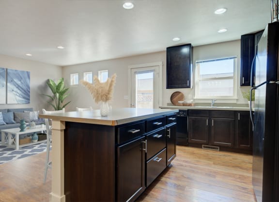 a kitchen with a center island and a living room  at Copper Pines, Bozeman, Montana