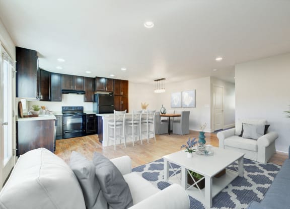 a living room and kitchen with white couches and a table at Copper Pines, Montana