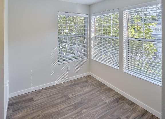 an empty room with wood flooring and three windows  at Edmonds Gateway, Edmonds, WA, 98026