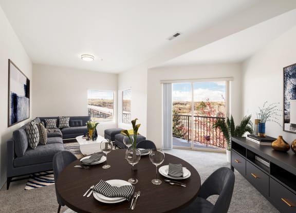 a dining area with a round table and chairs and a living room with a couch and wall art. at Shoreline Village, Richland Washington