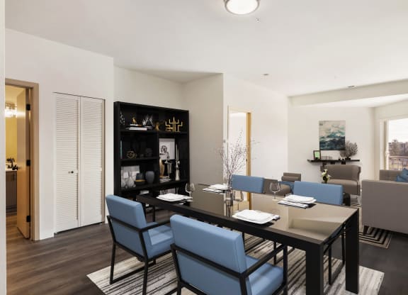 a dining room with a table, 4 blue chairs and the living room behind.at Shoreline Village, Richland, 99352