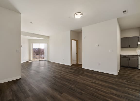 Large living area with wood flooring, bright white walls and sunny glass doors to balcony.at Shoreline Village, Richland Washington