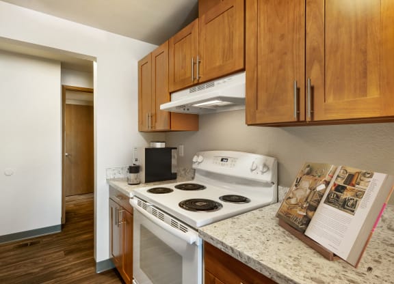 a kitchen with white appliances and wood cabinets  Kitchen at Cedarwood, Washington